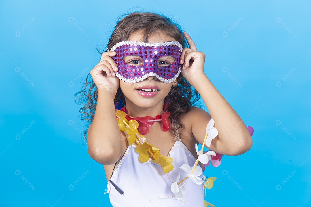 Linda menina com máscara carnavalescas sobre fundo isolado azul.