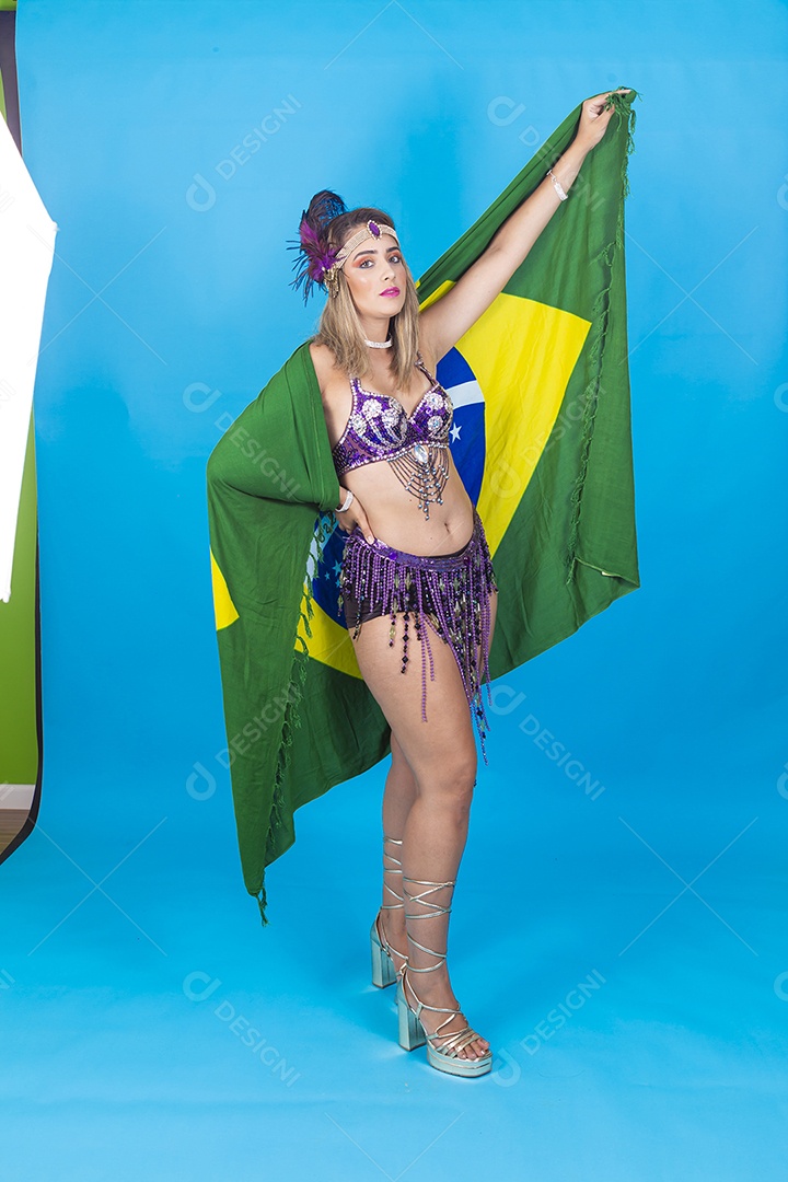 Linda jovem com fantasia de carnaval segurando bandeira do Brasil.