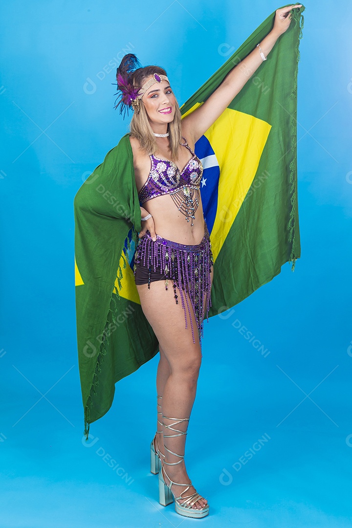 Linda jovem com fantasia de carnaval segurando bandeira do Brasil.
