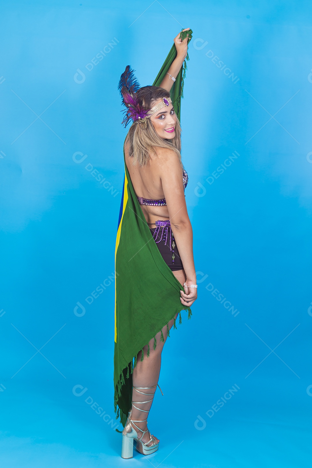 Linda jovem com fantasia de carnaval segurando bandeira do Brasil.