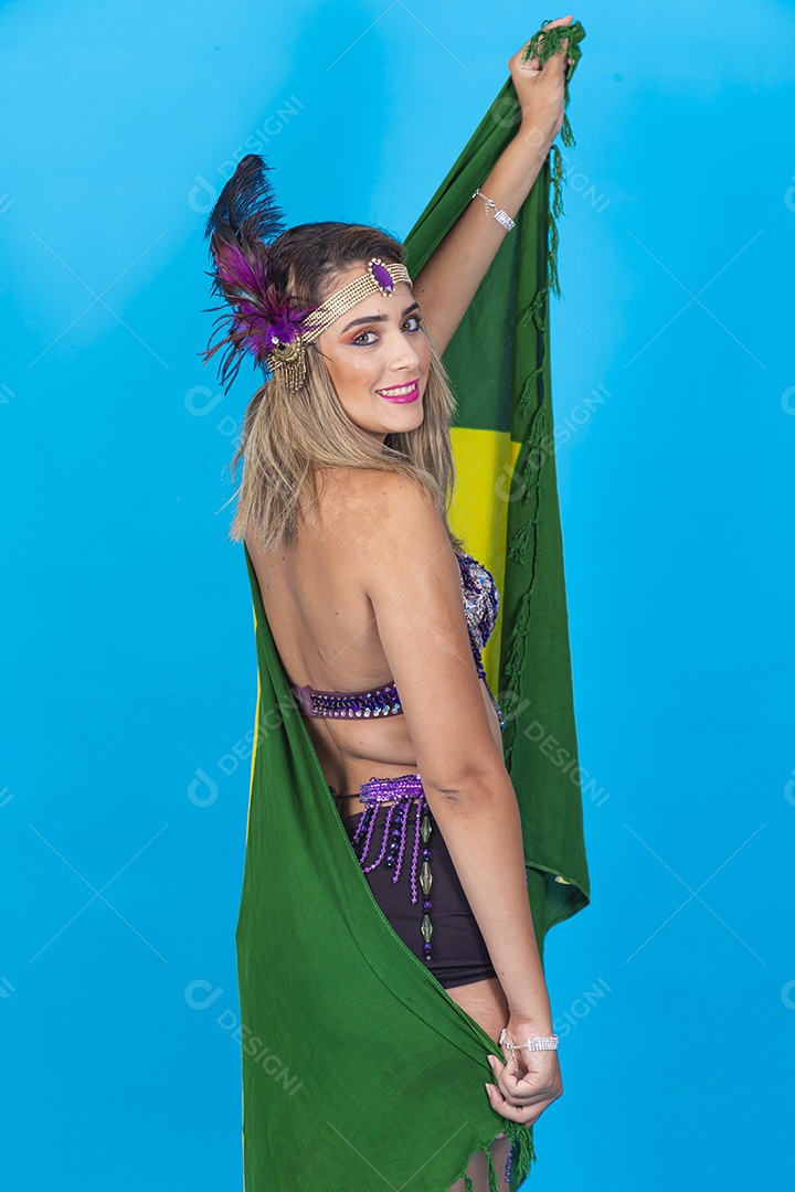 Linda jovem com fantasia de carnaval segurando bandeira do Brasil.