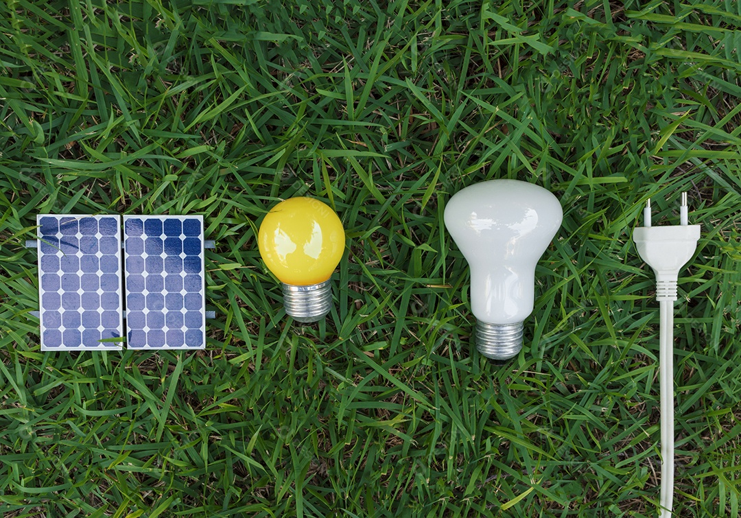 Painel solar fotovoltaico lâmpada fio de tomada e celular em fundo de grama verde