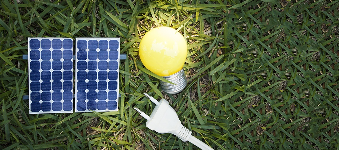 Painel solar fotovoltaico lâmpada fio de tomada e celular em fundo de grama verde