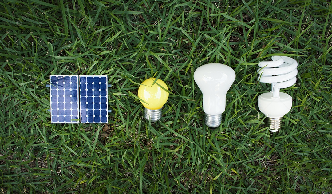 Painel solar fotovoltaico lâmpada fio de tomada e celular em fundo de grama verde