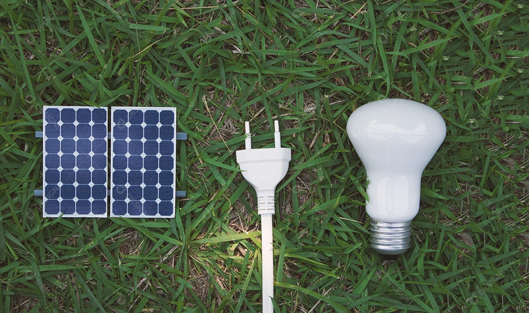 Painel solar fotovoltaico lâmpada fio de tomada e celular em fundo de grama verde