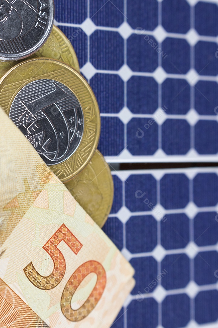 Dinheiro e painel de energia solar fotovoltaica brasileiro notas e moedas brasileiras em cima de um painel solar