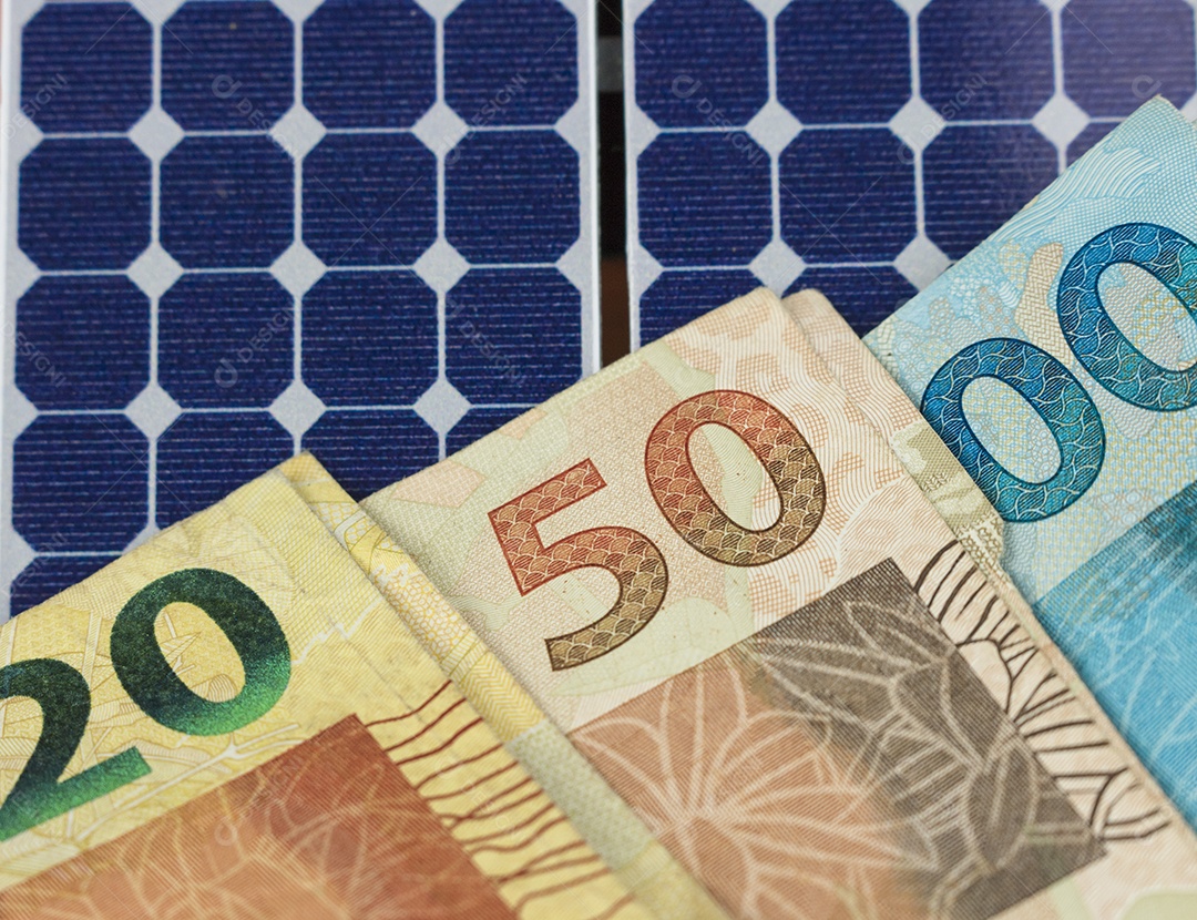 Dinheiro e painel de energia solar fotovoltaica brasileiro notas e moedas brasileiras em cima de um painel solar