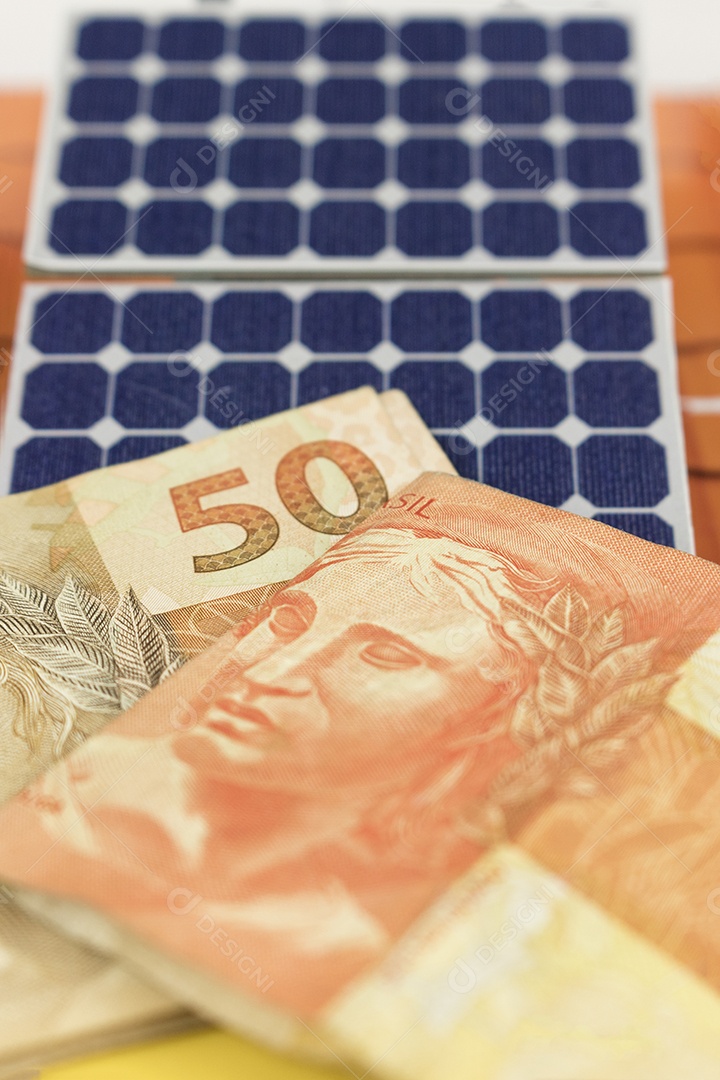 Dinheiro e painel de energia solar fotovoltaica brasileiro notas e moedas brasileiras em cima de um painel solar