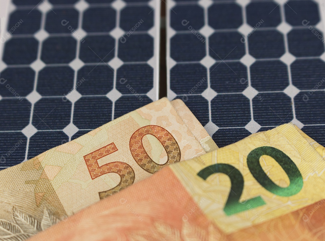 Dinheiro e painel de energia solar fotovoltaica brasileiro notas e moedas brasileiras em cima de um painel solar