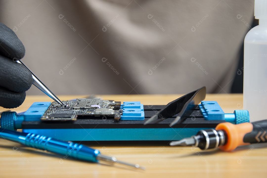 O técnico está reparando a placa mãe do Smartphone