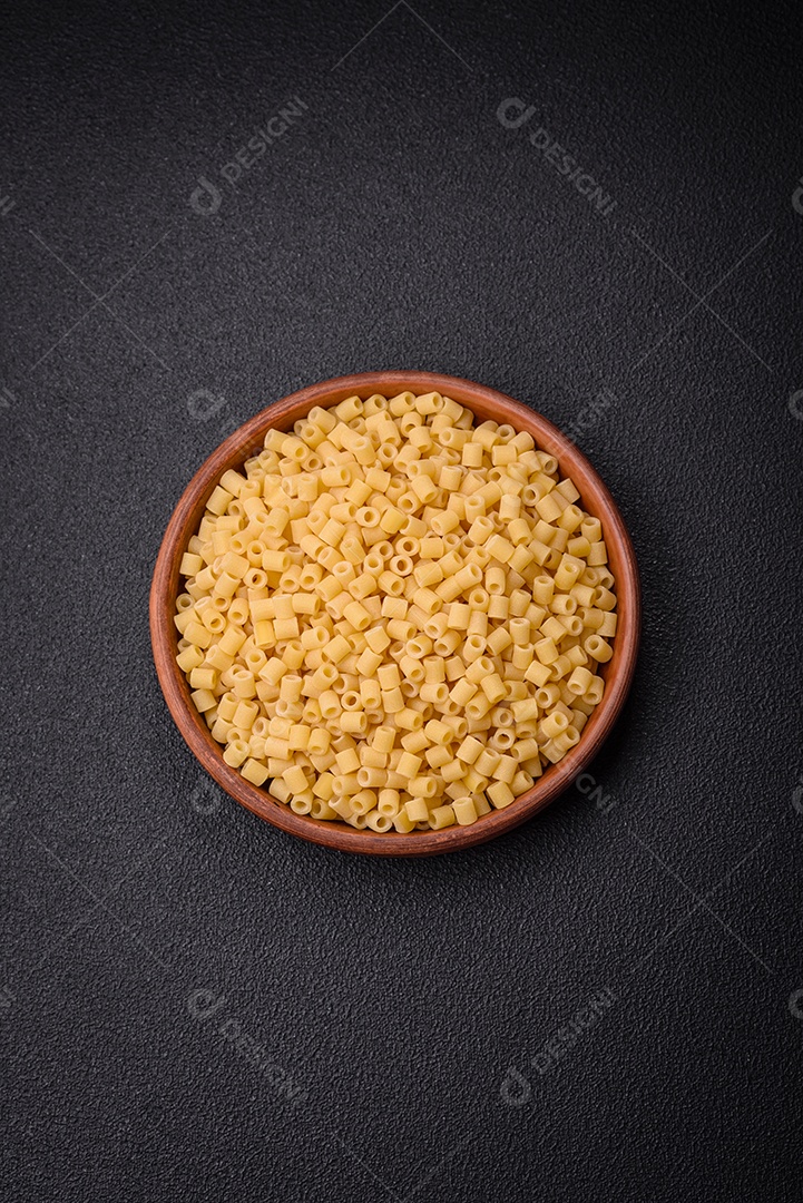 Deliciosa massa ditali de trigo duro com sal e especiarias sobre um fundo escuro de concreto