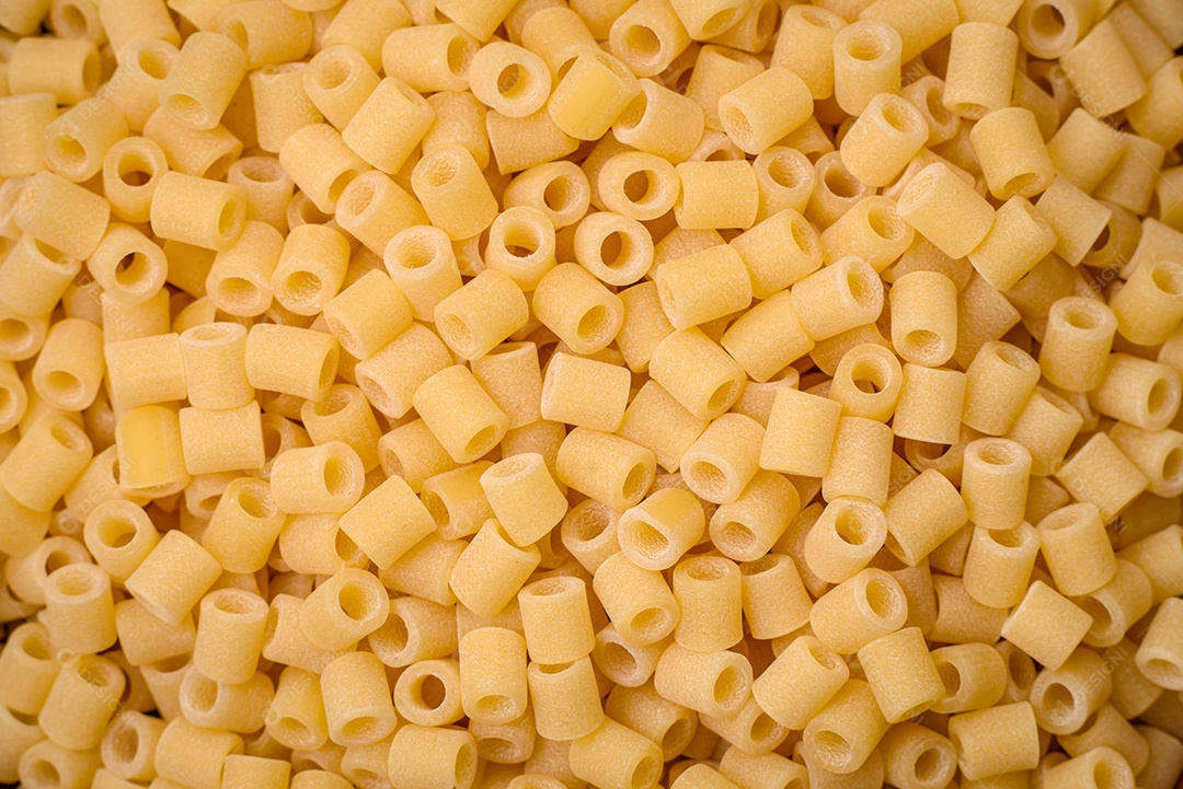 Deliciosa massa ditali de trigo duro com sal e especiarias sobre um fundo escuro de concreto