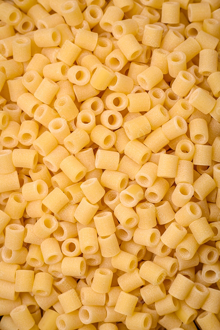 Deliciosa massa ditali de trigo duro com sal e especiarias sobre um fundo escuro de concreto