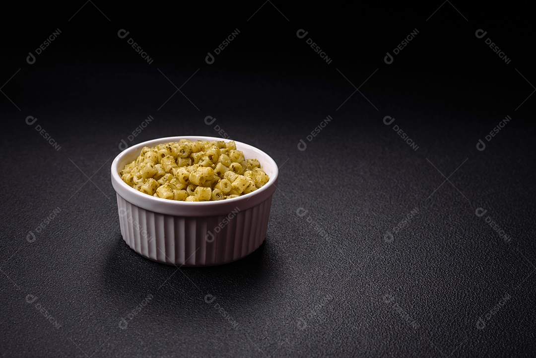 Deliciosa massa ditali de trigo duro com sal e especiarias sobre um fundo escuro de concreto