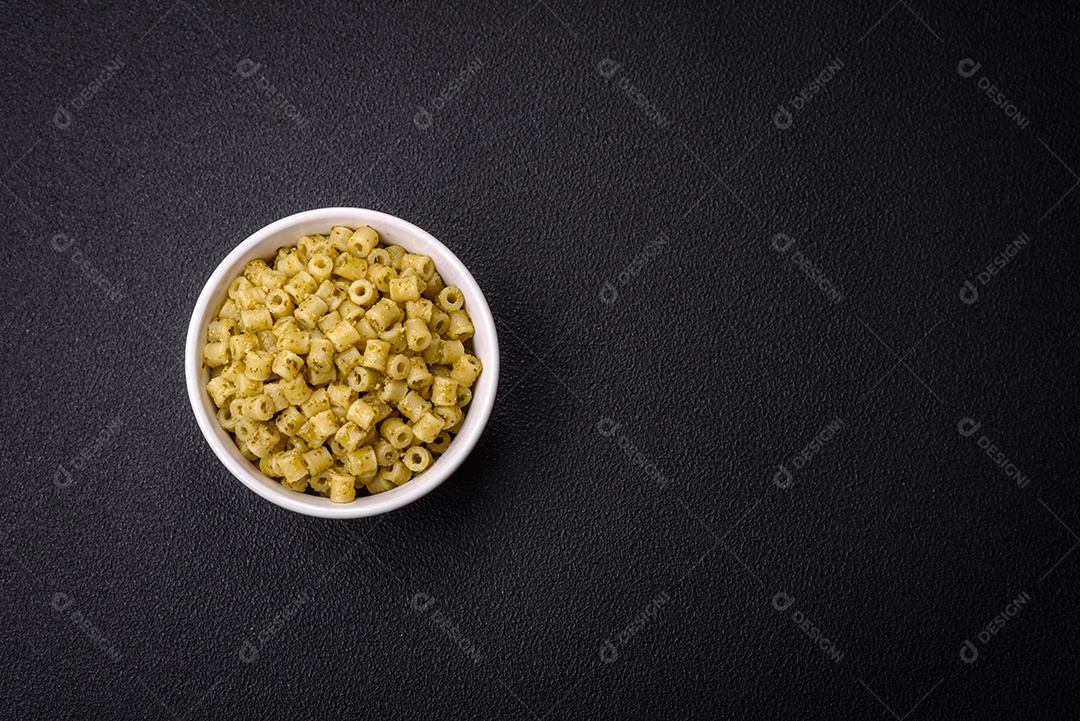 Deliciosa massa ditali de trigo duro com sal e especiarias sobre um fundo escuro de concreto