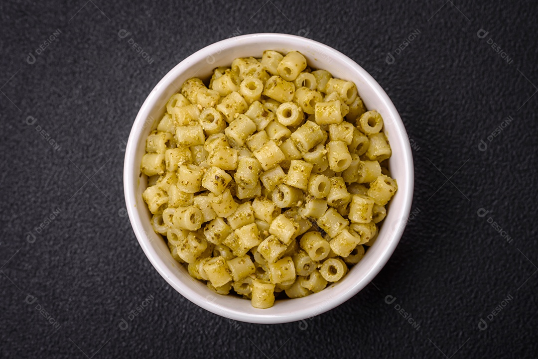 Deliciosa massa ditali de trigo duro com sal e especiarias sobre um fundo escuro de concreto