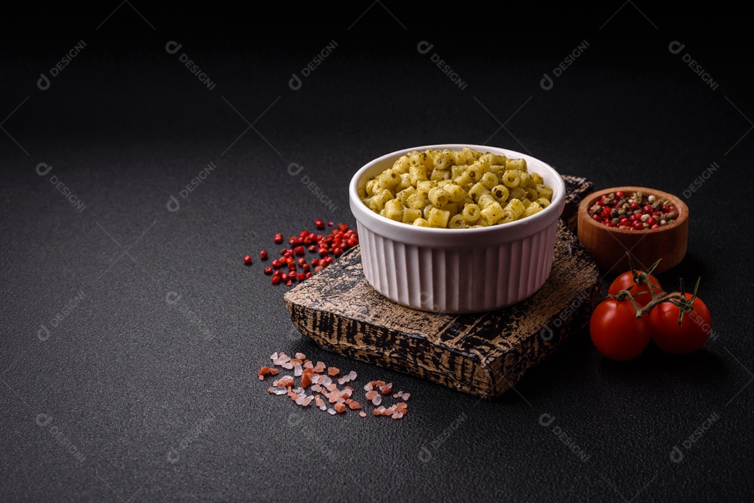 Deliciosa massa ditali de trigo duro com sal e especiarias sobre um fundo escuro de concreto