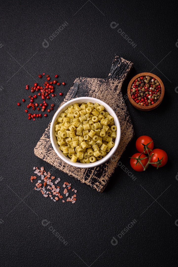 Deliciosa massa ditali de trigo duro com sal e especiarias sobre um fundo escuro de concreto