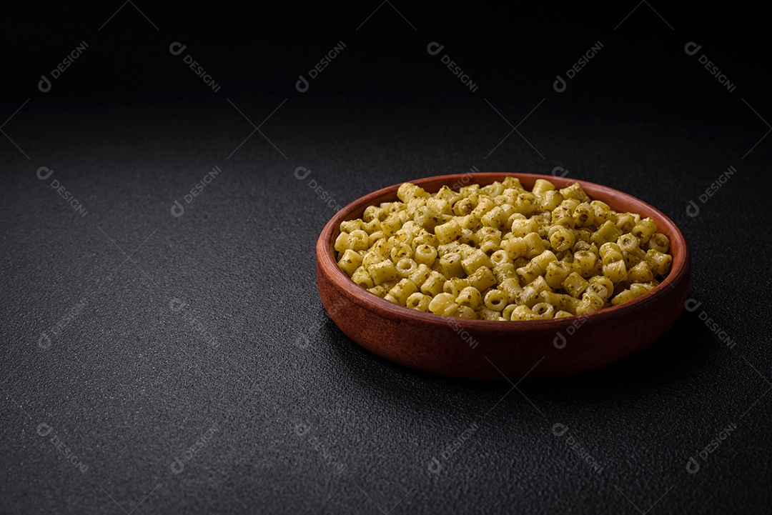 Deliciosa massa ditali de trigo duro com sal e especiarias sobre um fundo escuro de concreto