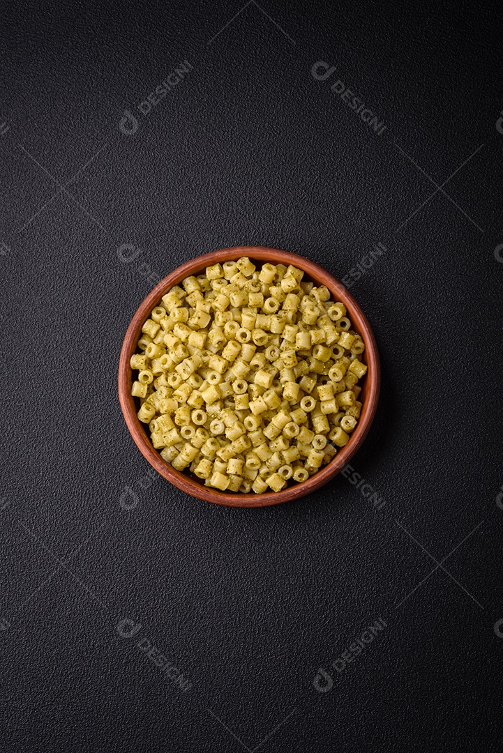 Deliciosa massa ditali de trigo duro com sal e especiarias sobre um fundo escuro de concreto