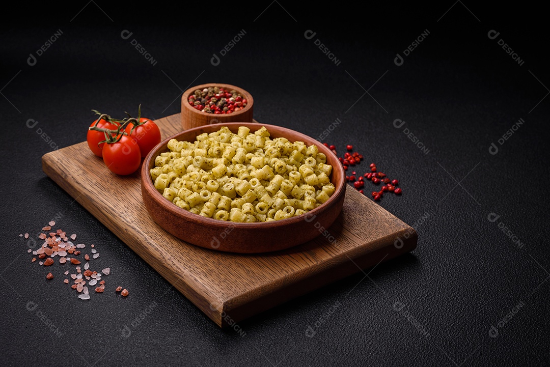 Deliciosa massa ditali de trigo duro com sal e especiarias sobre um fundo escuro de concreto