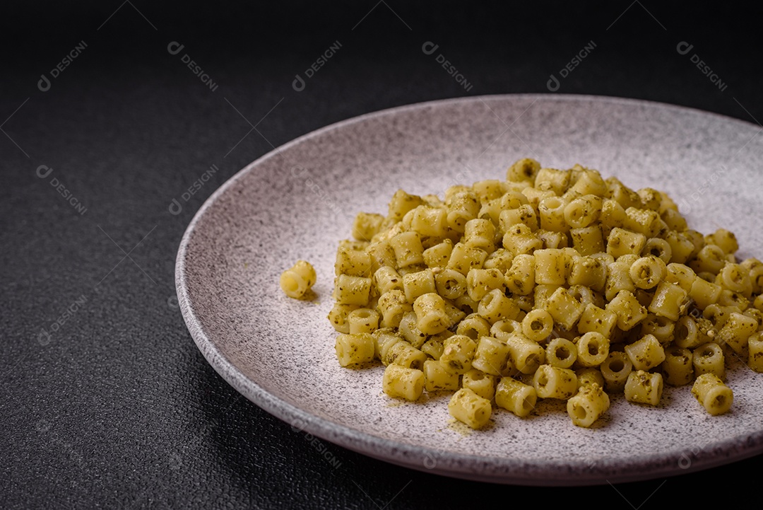 Deliciosa massa ditali de trigo duro com sal e especiarias sobre um fundo escuro de concreto