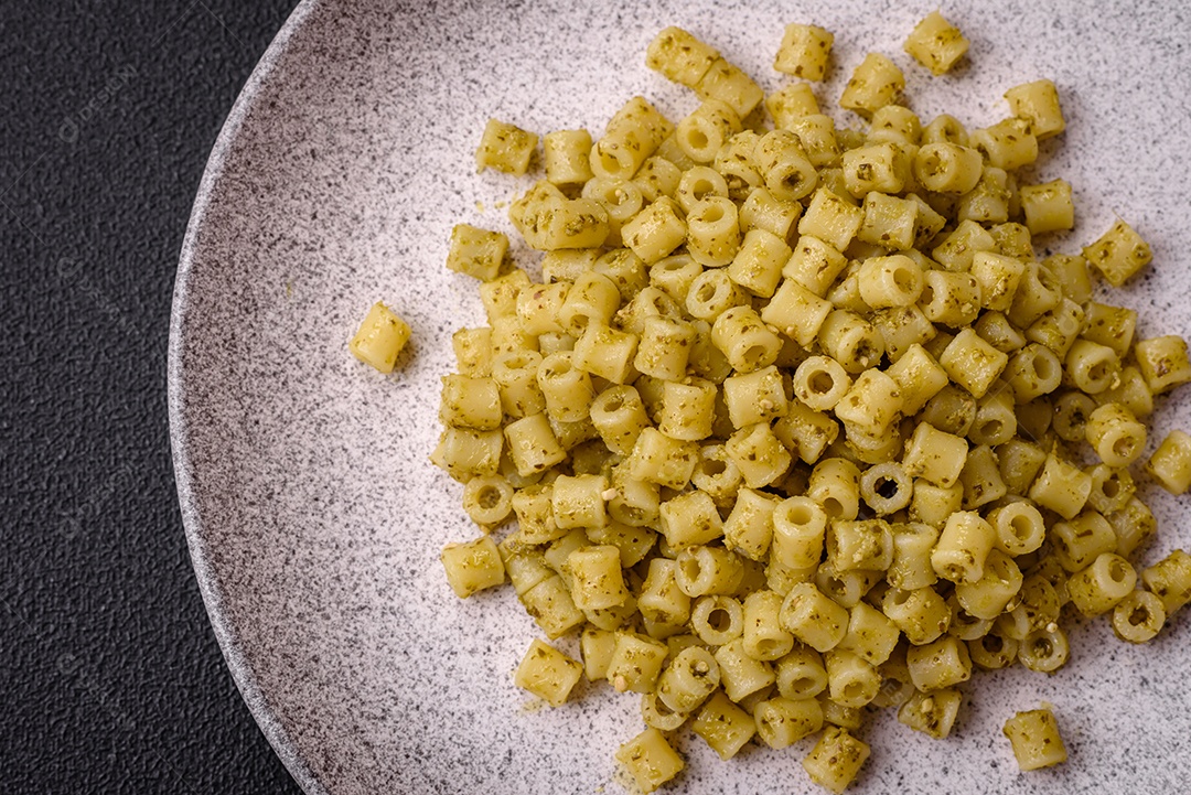 Deliciosa massa ditali de trigo duro com sal e especiarias sobre um fundo escuro de concreto