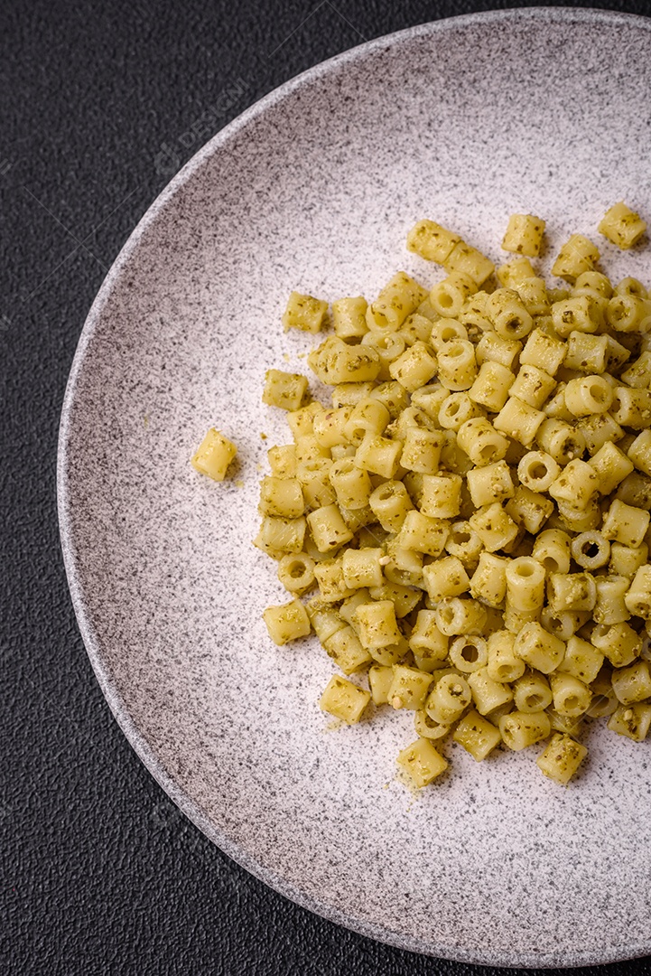 Deliciosa massa ditali de trigo duro com sal e especiarias sobre um fundo escuro de concreto