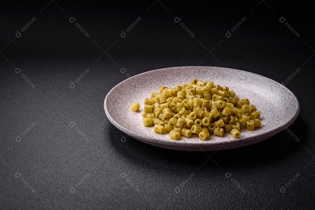 Deliciosa massa ditali de trigo duro com sal e especiarias sobre um fundo escuro de concreto