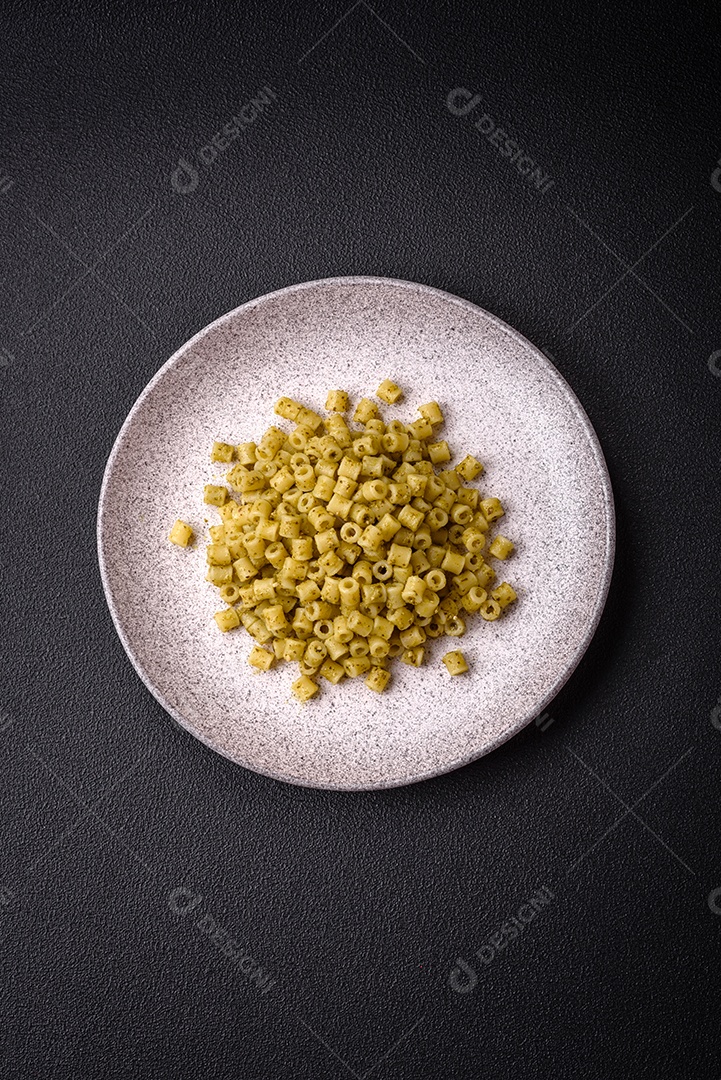 Deliciosa massa ditali de trigo duro com sal e especiarias sobre um fundo escuro de concreto