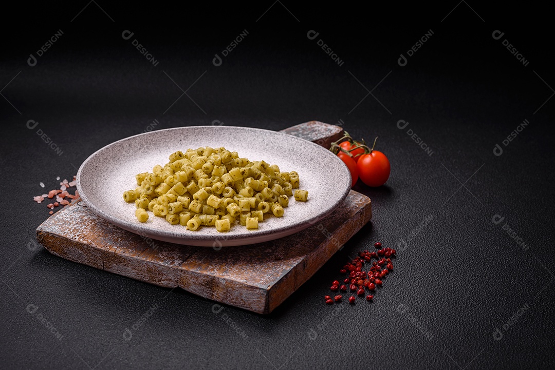 Deliciosa massa ditali de trigo duro com sal e especiarias sobre um fundo escuro de concreto