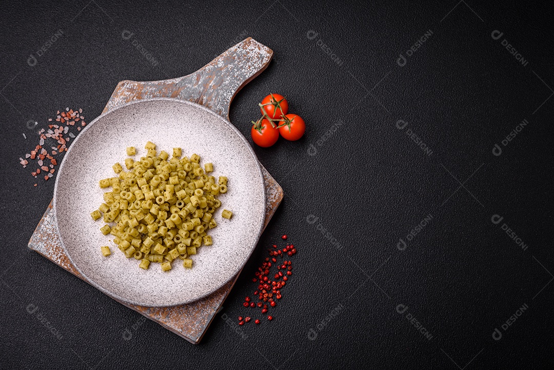 Deliciosa massa ditali de trigo duro com sal e especiarias sobre um fundo escuro de concreto