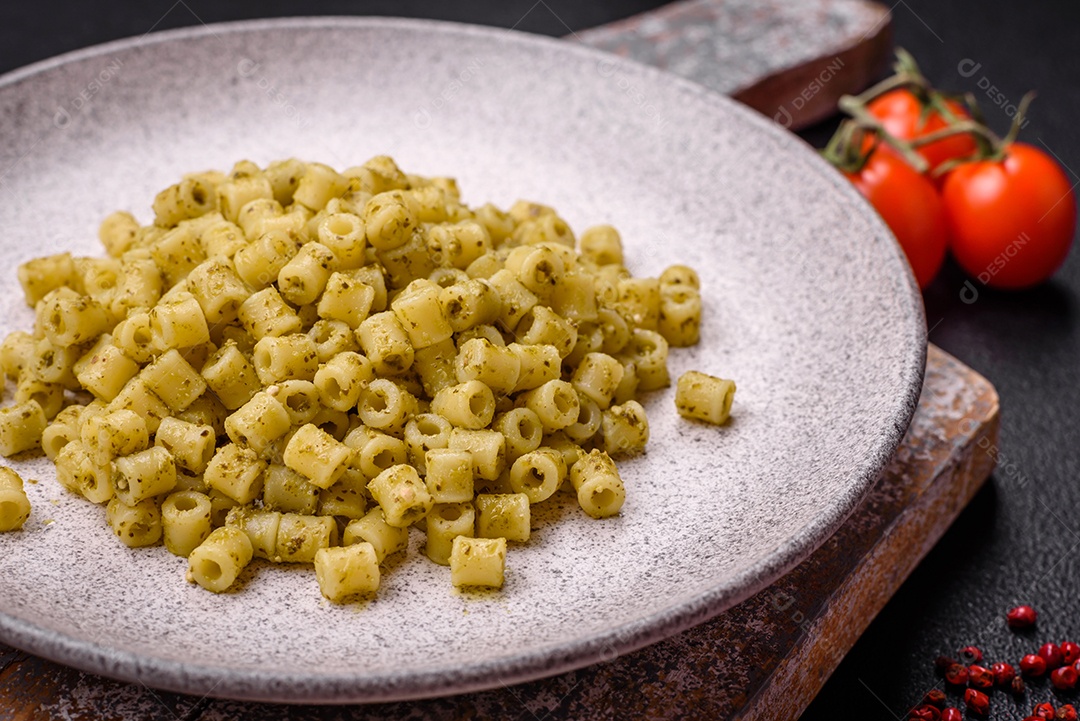 Deliciosa massa ditali de trigo duro com sal e especiarias sobre um fundo escuro de concreto