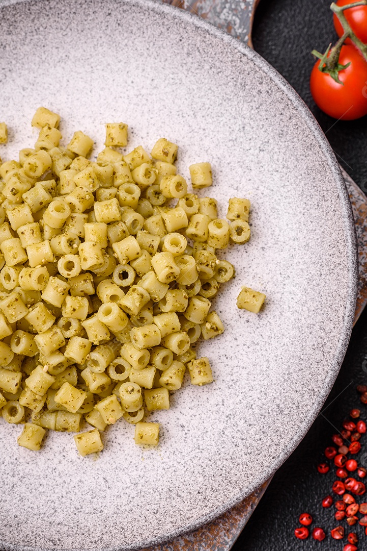 Deliciosa massa ditali de trigo duro com sal e especiarias sobre um fundo escuro de concreto