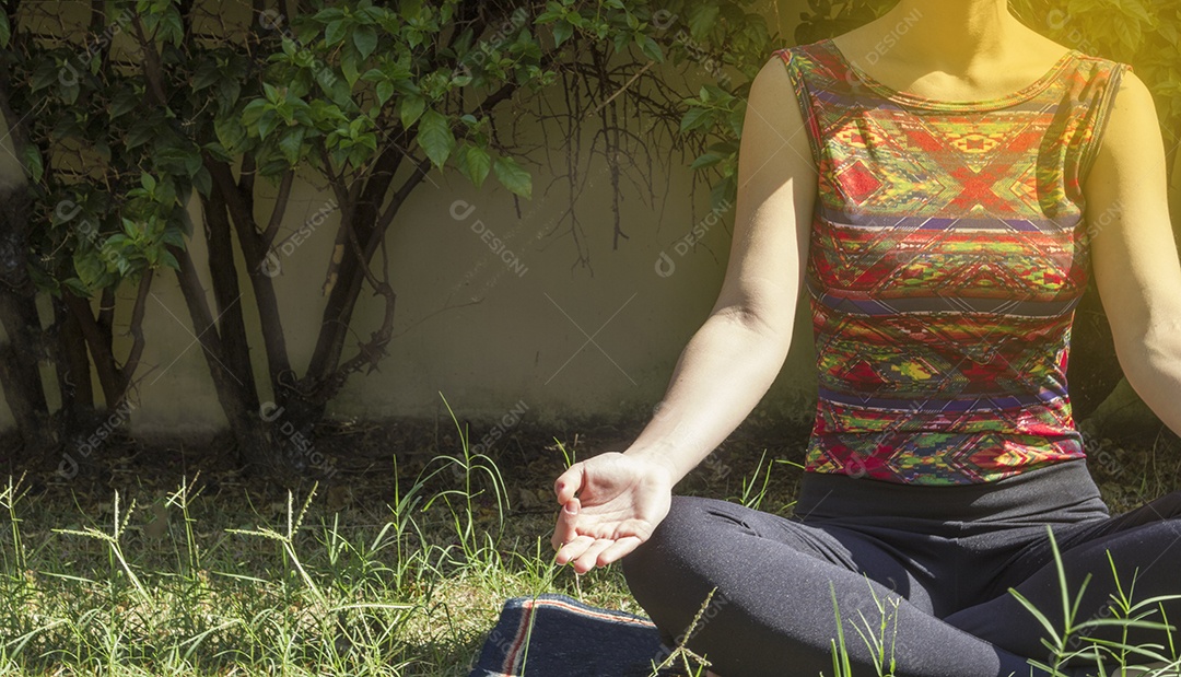Jovem brasileira praticando ioga no jardim da casa com sol e flores Imagem conceitual de ioga