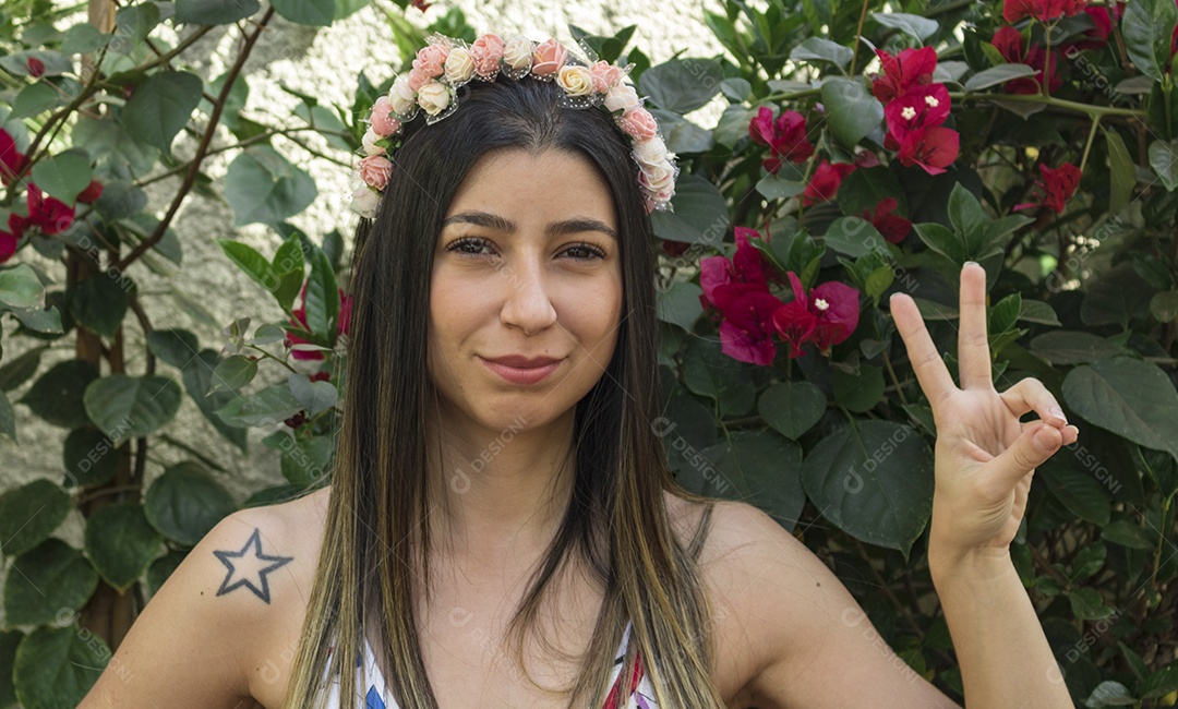 Menina adolescente morena bonita com tiara florida ou faixa de cabelo no jardim conceito de fantasia hippie