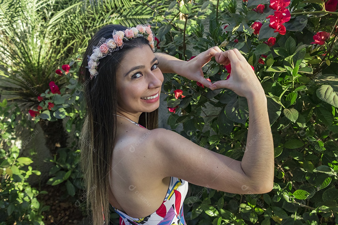 Menina adolescente morena bonita com tiara florida ou faixa de cabelo no jardim conceito de fantasia hippie