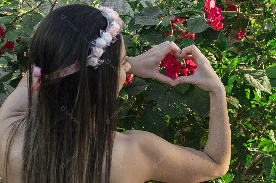 Menina adolescente morena bonita com tiara florida ou faixa de cabelo no jardim conceito de fantasia hippie