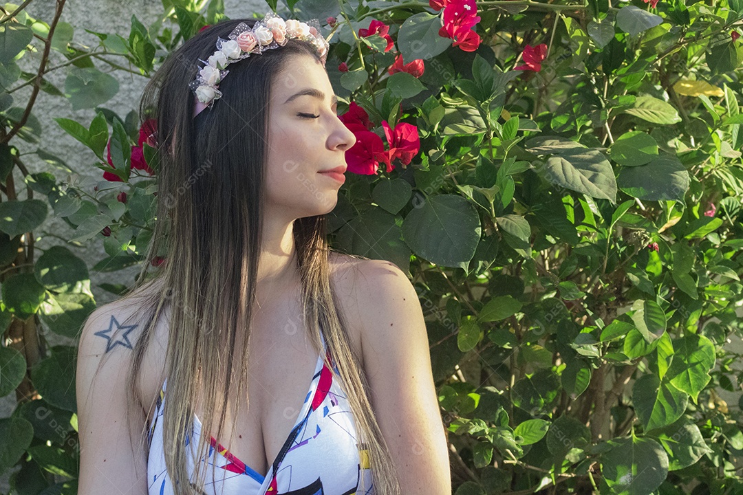 Menina adolescente morena bonita com tiara florida ou faixa de cabelo no jardim conceito de fantasia hippie