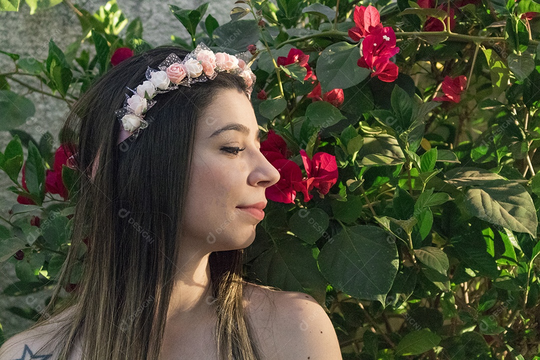 Menina adolescente morena bonita com tiara florida ou faixa de cabelo no jardim conceito de fantasia hippie