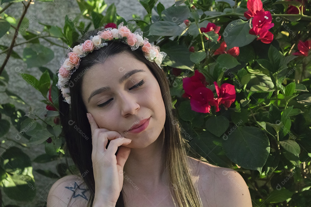 Menina adolescente morena bonita com tiara florida ou faixa de cabelo no jardim conceito de fantasia hippie