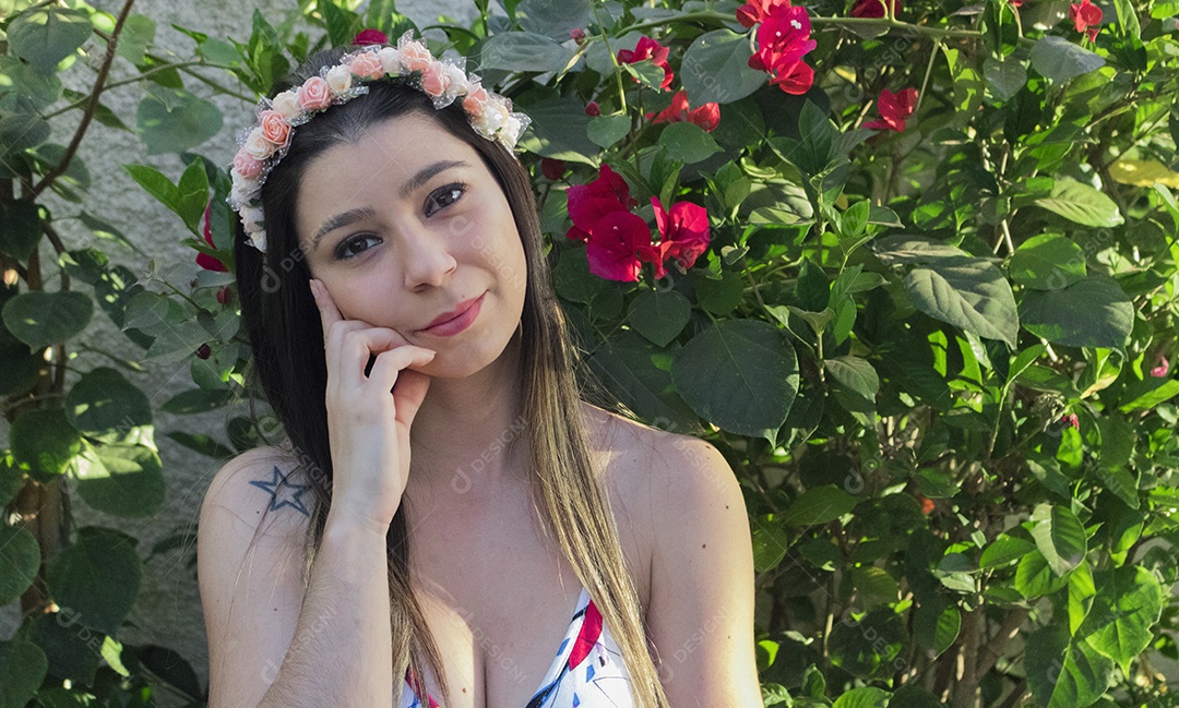 Menina adolescente morena bonita com tiara florida ou faixa de cabelo no jardim conceito de fantasia hippie