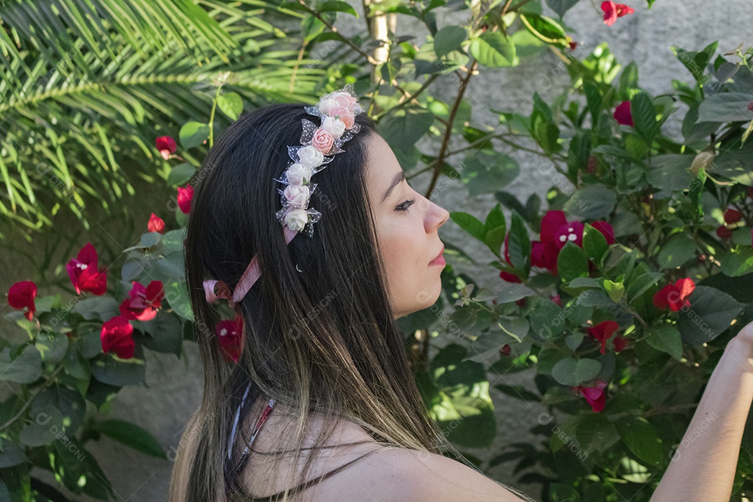 Menina adolescente morena bonita com tiara florida ou faixa de cabelo no jardim conceito de fantasia hippie