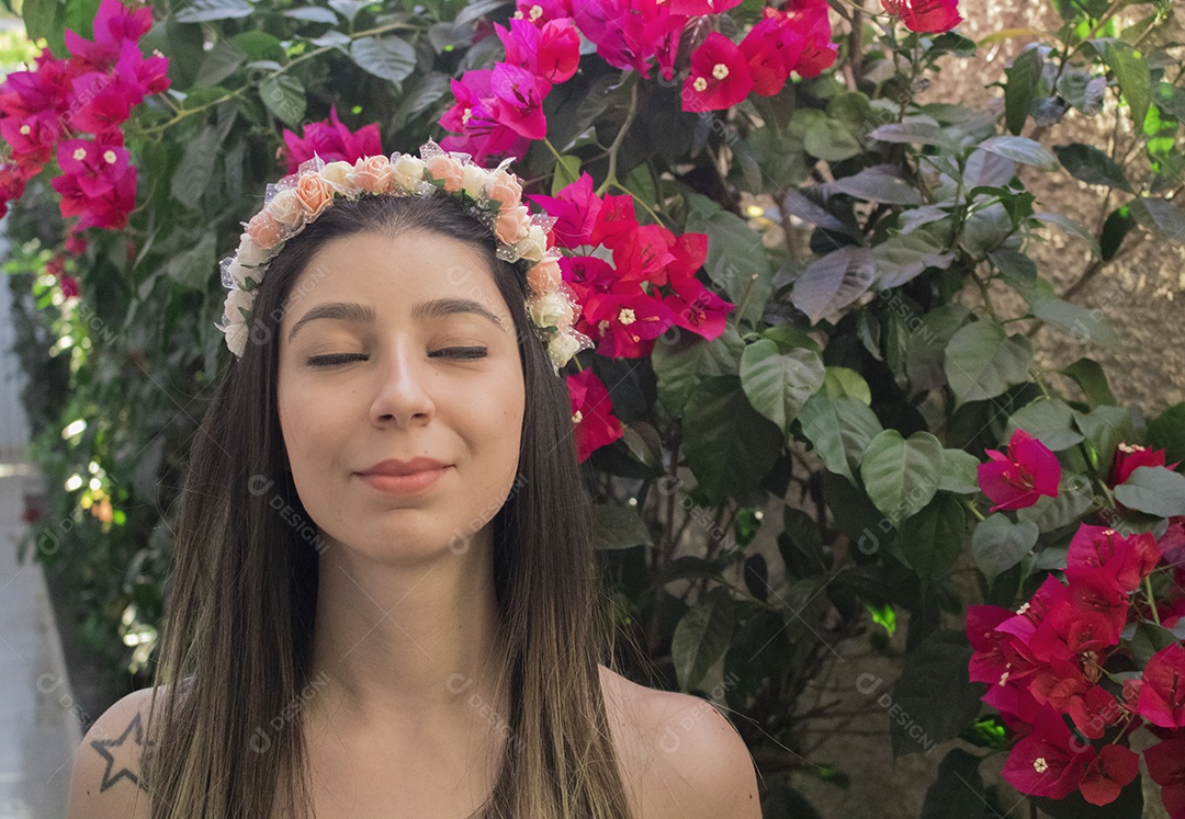 Menina adolescente morena bonita com tiara florida ou faixa de cabelo no jardim conceito de fantasia hippie