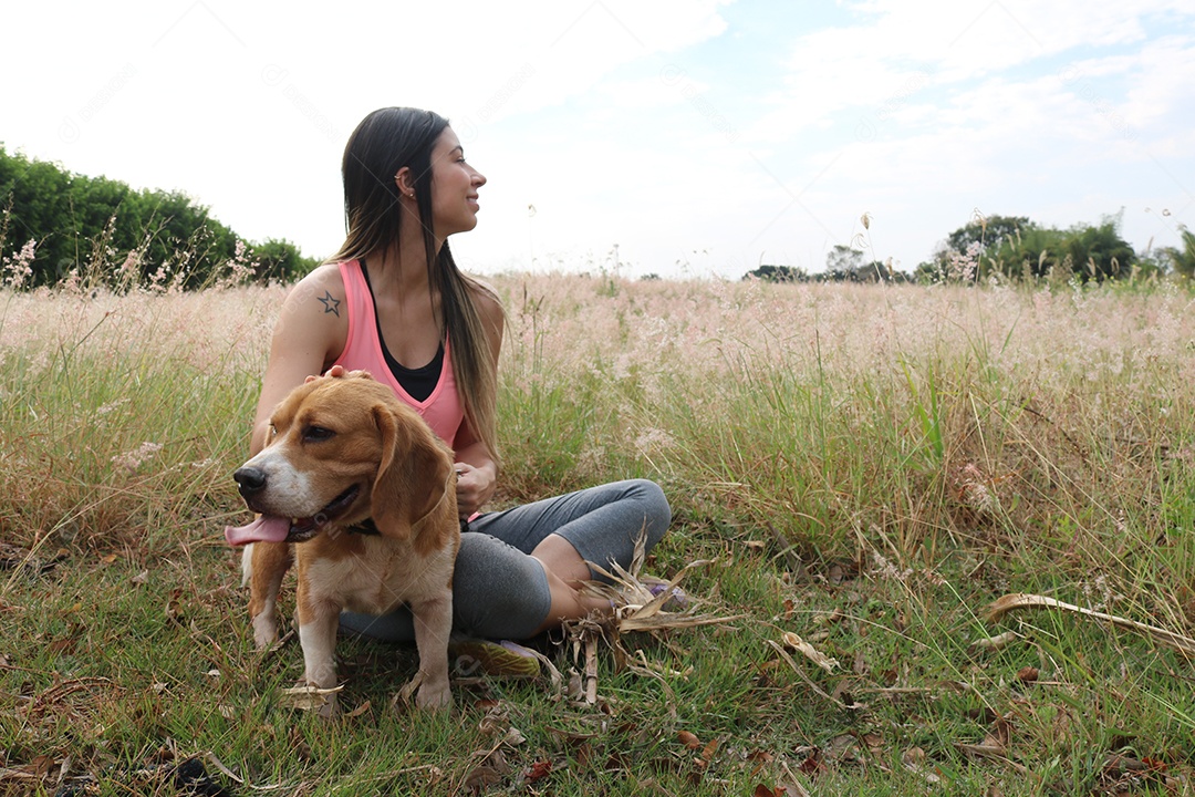 Adolescente morena com cachorro beagle no parque ao ar livre