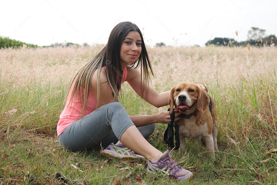 Adolescente morena com cachorro beagle no parque ao ar livre