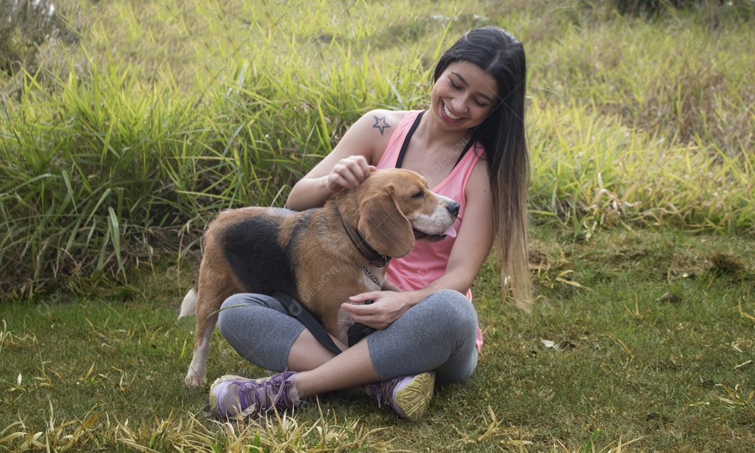 Adolescente morena com cachorro beagle no parque ao ar livre