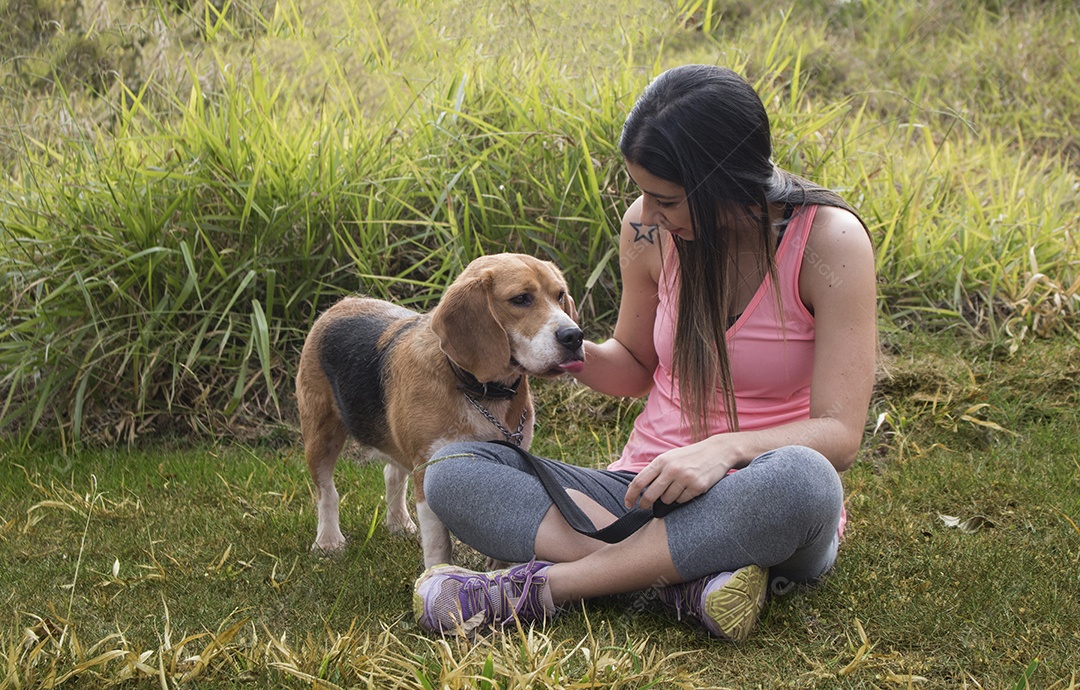 Adolescente morena com cachorro beagle no parque ao ar livre
