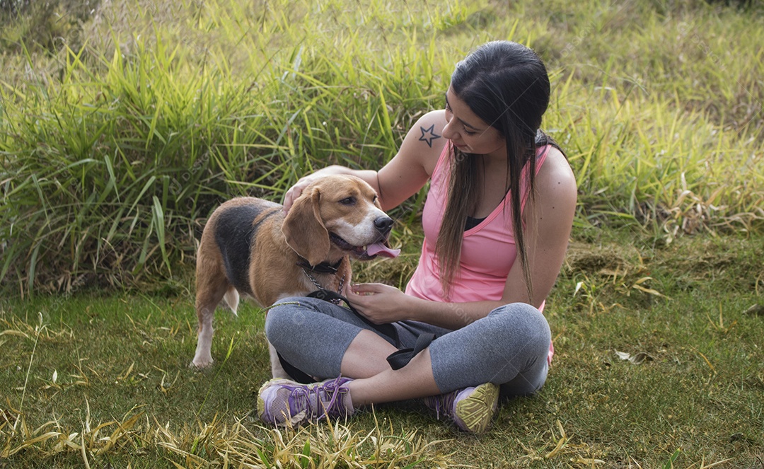 Adolescente morena com cachorro beagle no parque ao ar livre