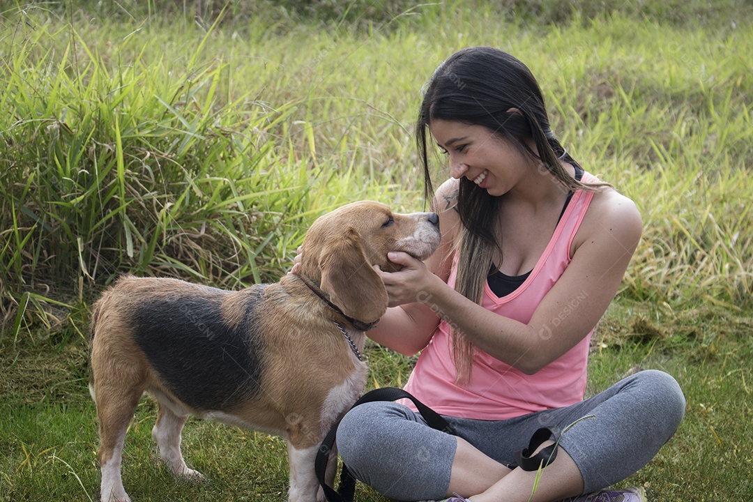 Adolescente morena com cachorro beagle no parque ao ar livre